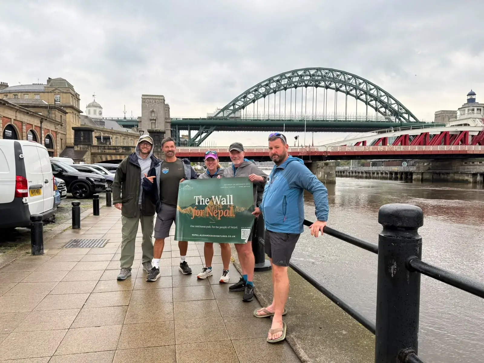 The team at the Newcastle Quayside holding The Wall for Nepal banner, the Tyne Bridge behind them